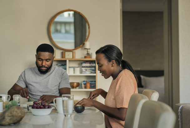 Sorridente giovane coppia afroamericana parlando insieme a colazione al loro tavolo da pranzo a casa al mattino
 - Foto, immagini