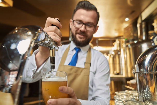 Barman pouring lager beer in cold glass. - Foto, Bild