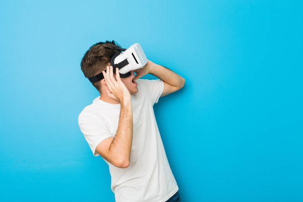 Nastolatek kaukaski mężczyzna za pomocą okulary wirtualnej rzeczywistości - Zdjęcie, obraz