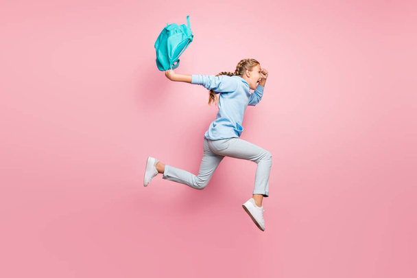 Full body profile photo of pretty little lady jumping high rushing home after studying week wear pupil backpack casual sweater clothes isolated pink color background - Foto, imagen