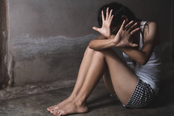 Mujer joven asustada sentada en la esquina de su dormitorio, desesperación
 - Foto, Imagen
