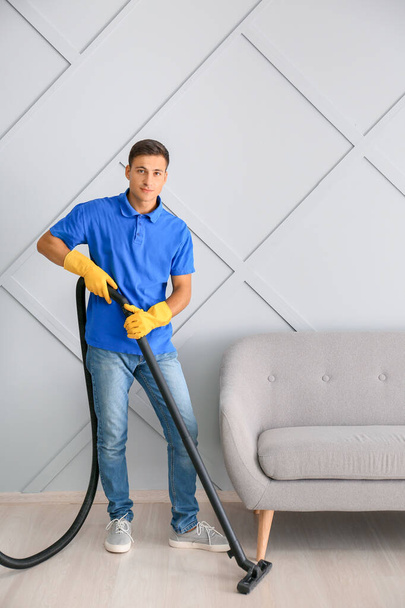 Jeune homme nettoyer son appartement - Photo, image