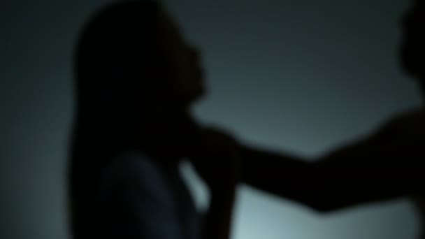 4k. Der Schatten eines Mannes erwürgt die Frau mit der Hand am Hals. Mann missbraucht Gewalt, um Ehefrau anzugreifen. Stoppt häusliche Gewalt gegen Frauen und Kampagne gegen Menschenhandel. - Filmmaterial, Video