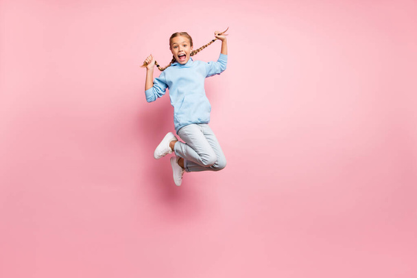 Full length body size photo of cheerful positive ecstatic overjoyed rejoicing girl jumping up wearing jeans denim blue sweatshirt sweater isolated over pastel color background - Foto, imagen
