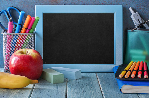 Stationery and fruits on a table in front of blackboard with tex - Foto, immagini