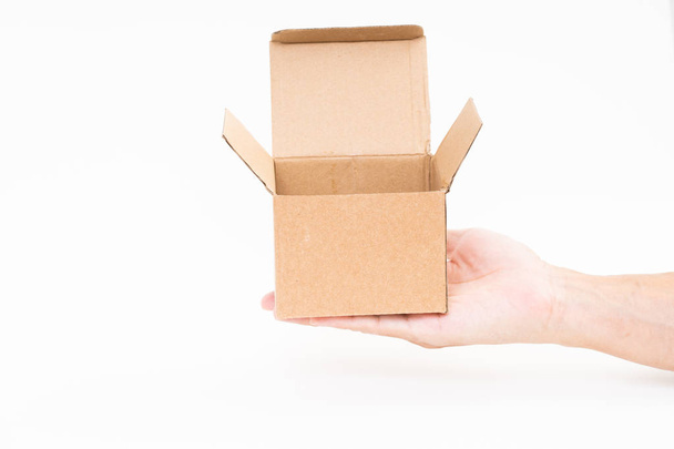 Man hand holding brown paper box on white background - Фото, изображение