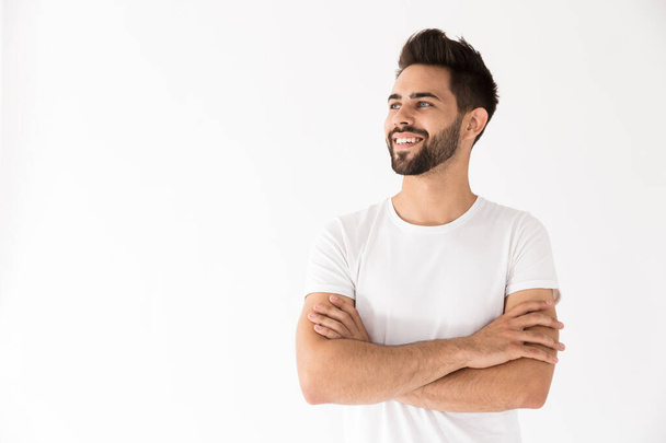 Image of attractive young man smiling and looking aside at copyspace - Φωτογραφία, εικόνα