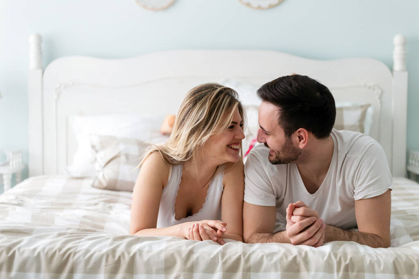 Young happy couple having romantic time in bedroom - Foto, Imagem