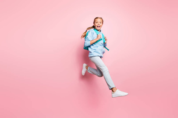 Full body profile photo of pretty little lady jumping high walking 1 september to school wear pupil backpack casual sweater clothes isolated pink color background - Foto, imagen