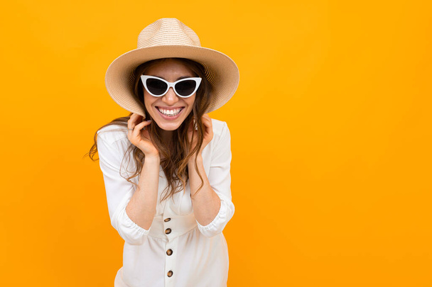 γυναίκα με καπέλο που ποζάρει σε πορτοκαλί φόντο  - Φωτογραφία, εικόνα