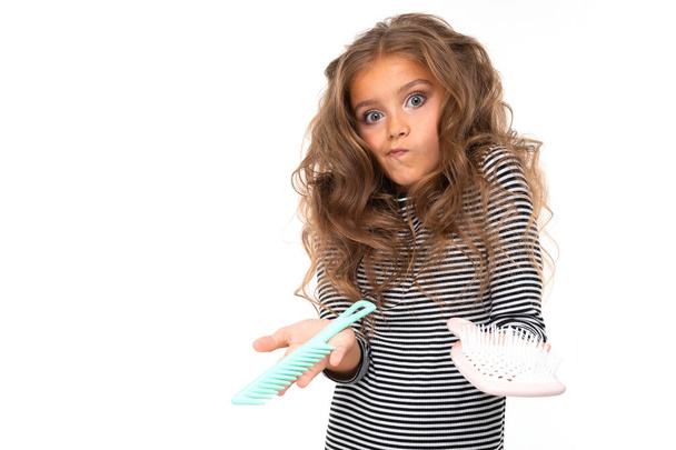 carino bambina posa con spazzole per capelli contro sfondo bianco
   - Foto, immagini