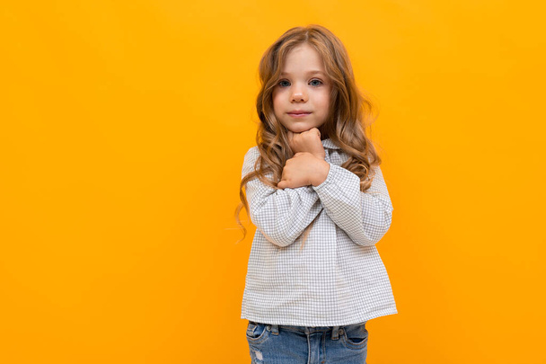 Nettes kleines Mädchen posiert vor orangefarbenem Hintergrund - Foto, Bild