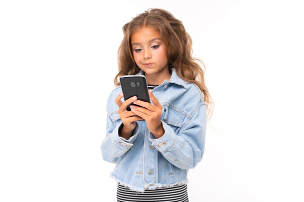 cute little girl posing with mobile phone against white background   - Фото, зображення
