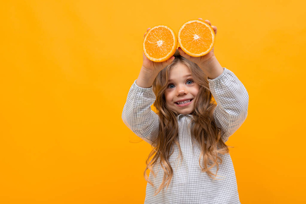 cute little girl posing against orange background - 写真・画像