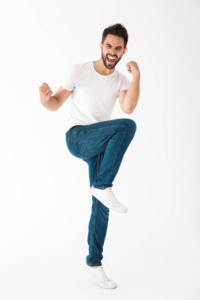 Full length of a cheerful young brunette bearded man - Foto, afbeelding