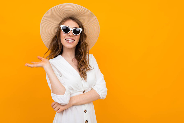 woman in hat posing on orange background  - Valokuva, kuva