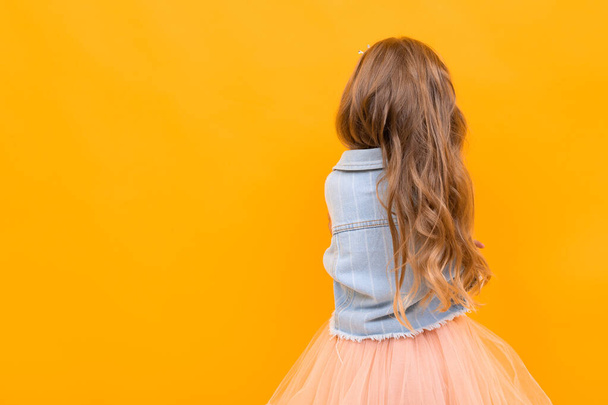 mignonne petite fille posant sur fond orange
 - Photo, image