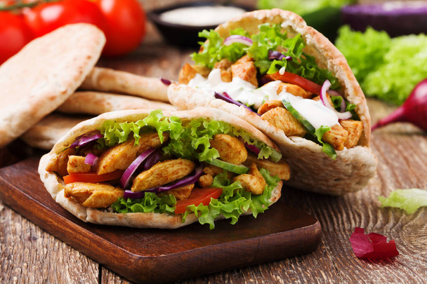 Pita salad with roasted chicken and vegetables, served with a de - Photo, Image