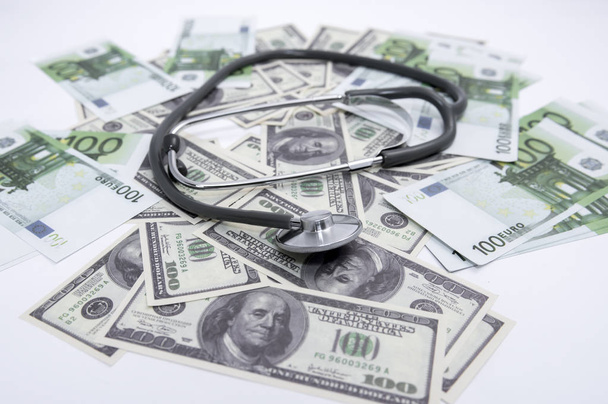 medical stethoscope on dollars and euro banknotes - Foto, Bild