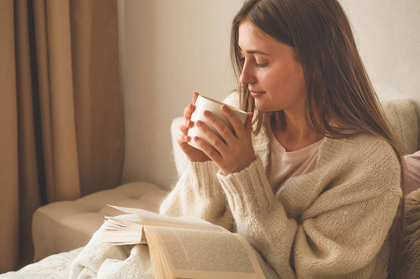 Уютный осенний зимний вечер. Женщина пьет горячий чай и отдыхает дома
.  - Фото, изображение