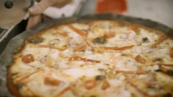 Handheld macro shot van verse zeevruchten pizza in stukken gesneden - Video