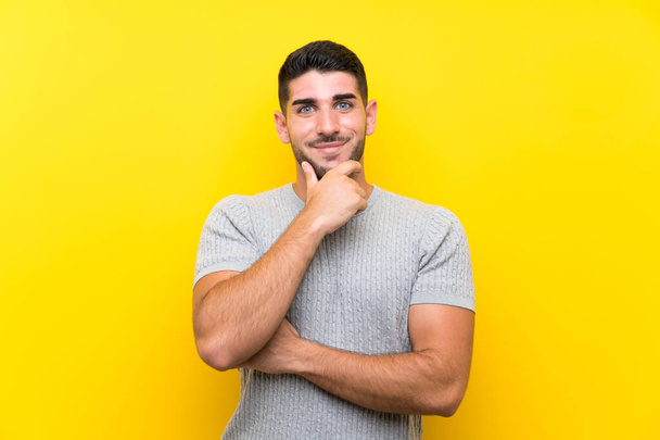 Young handsome man over isolated yellow background laughing - Foto, Imagen