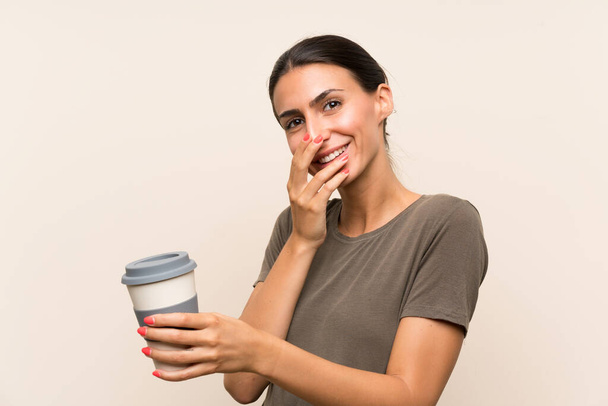 Fiatal nő kezében egy elvitelre kávét vigyorog sokat - Fotó, kép