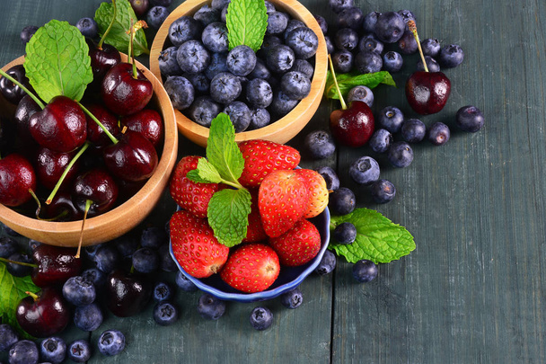 Fresh fruits berries, strawberry, cherries, blueberry on wooden background. - Фото, изображение