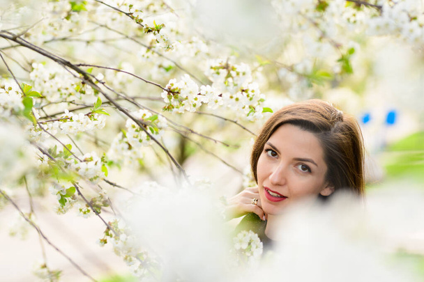 girl with flowers. Gorgeous model in the spring garden. girl near the tree in spring. the concept of spring. young garden. Blooming tree - Zdjęcie, obraz