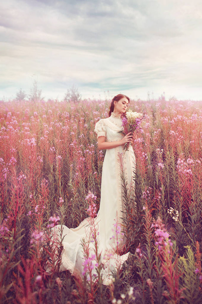 Elegant woman walk at field with bouquet of pink flowers. - Photo, image