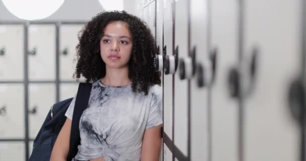 Portret van Afro-Amerikaanse middelbare school student door kluisjes - Video