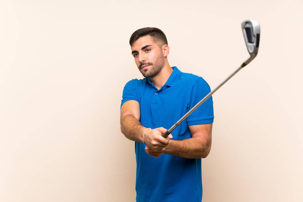 Young handsome golfer man over isolated background - Fotografie, Obrázek