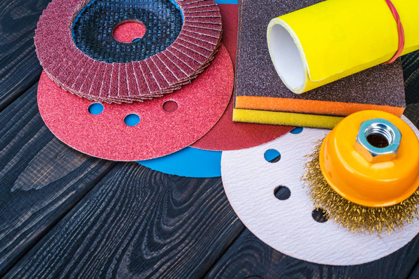 Ensemble d'outils abrasifs et de papier de verre de différentes couleurs sur fond en bois vintage noir
 - Photo, image