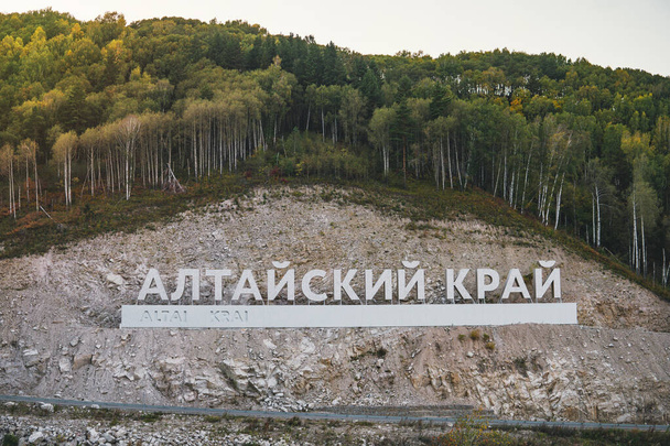 Inscrição em língua russa Altai Krai é o nome de uma região na Sibéria Ocidental, na Rússia. Cartas numa rocha perto da estrada serpentina. aglomerado turístico Belokurikha 2
 - Foto, Imagem