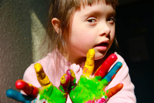 Χαριτωμένο μικρό παιδί με ζωγραφισμένα χέρια που απομονώνονται σε μαύρο - Φωτογραφία, εικόνα