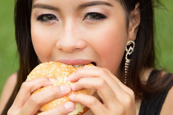 meisje een cheeseburger eten - Foto, afbeelding