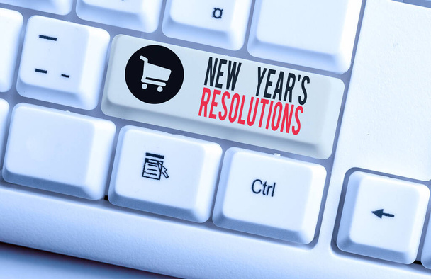 Handwriting text New Year S Resolutions. Concept meaning Wishlist List of things to accomplish or improve White pc keyboard with empty note paper above white background key copy space. - Photo, Image
