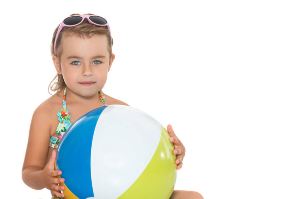 Little girl in a swimsuit with a ball.The concept of childrens - Foto, afbeelding