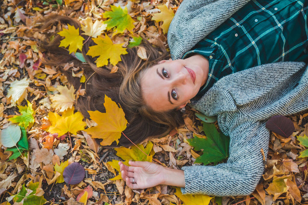 woman laying on the ground in autumn yellow leaves - Fotoğraf, Görsel