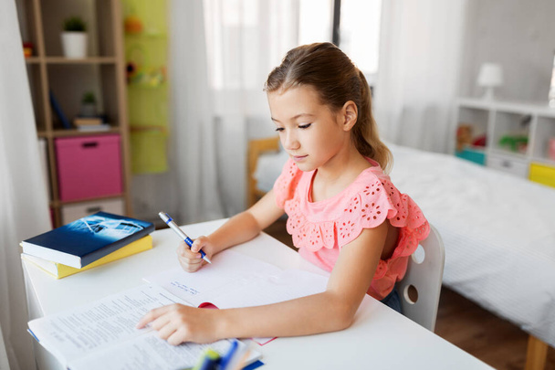 student girl with book writing to notebook at home - Photo, image