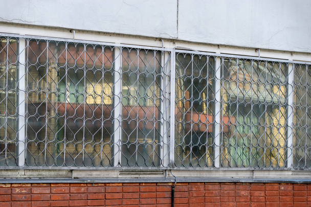 Grille de sécurité décorative en métal sur la fenêtre avec cœur répétitif et un détail de vieux mur craquelé en plâtre émietté
 - Photo, image