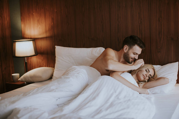 Krásný mladý pár objímání na jejich posteli doma - Fotografie, Obrázek