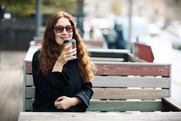 Miyop düzeltme gözlüklü güzel genç bayan kahve içmiş.  - Fotoğraf, Görsel