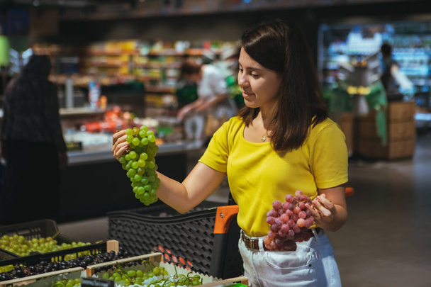 woman buying grapes in store - Photo, Image