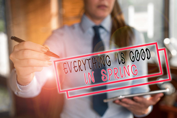 Text sign showing Everything Is Good In Spring. Conceptual photo Happiness for the season Enjoy nature Blurred woman in the background pointing with finger in empty space. - Photo, Image