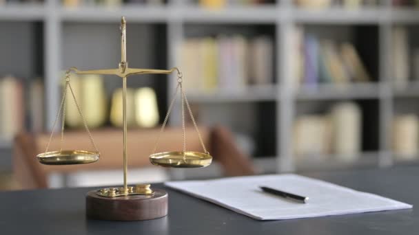 Escala de equilibrio de latón dorado con documento en la tabla de abogados
 - Imágenes, Vídeo