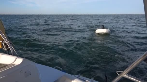 Nadmuchiwana łódź holowana przez jacht. Zwolniony ruch - Materiał filmowy, wideo