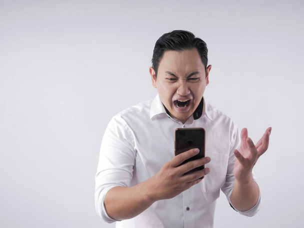 Young Man Getting Bad News on Phone, Shocked and Angry - 写真・画像