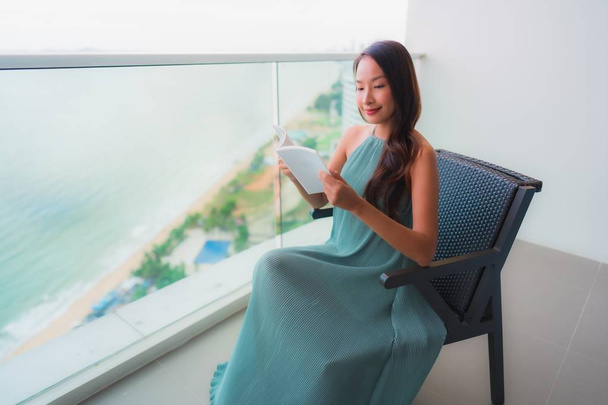 Beautiful portrait young asian woman  reading book at outdoor ba - Foto, Imagem