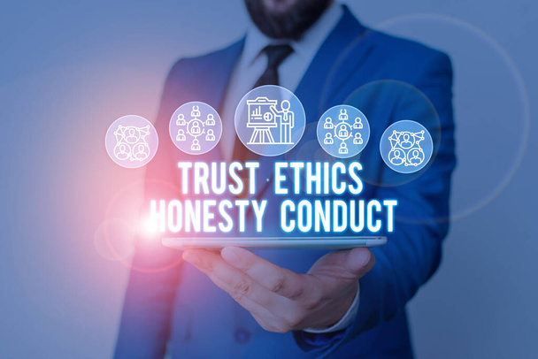 Käsiala tekstin kirjoittaminen Trust Ethics Rehellisyys Conduct. Käsitteen merkitys merkitsee positiivisia ja hyveellisiä ominaisuuksia Mies ihmisen kuluminen muodollinen työpuku esittäminen älylaitteella
. - Valokuva, kuva